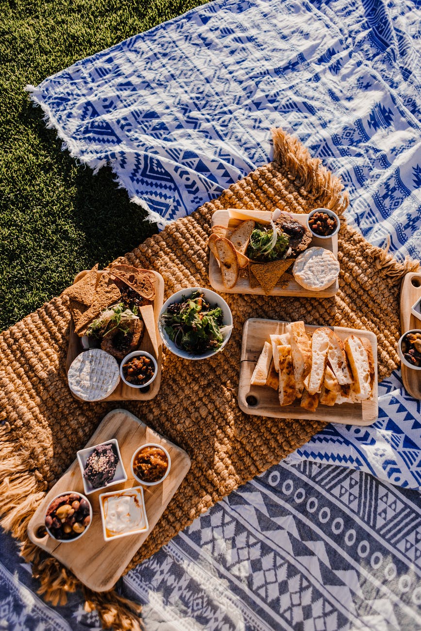 bread and snacks on blanket in meadow